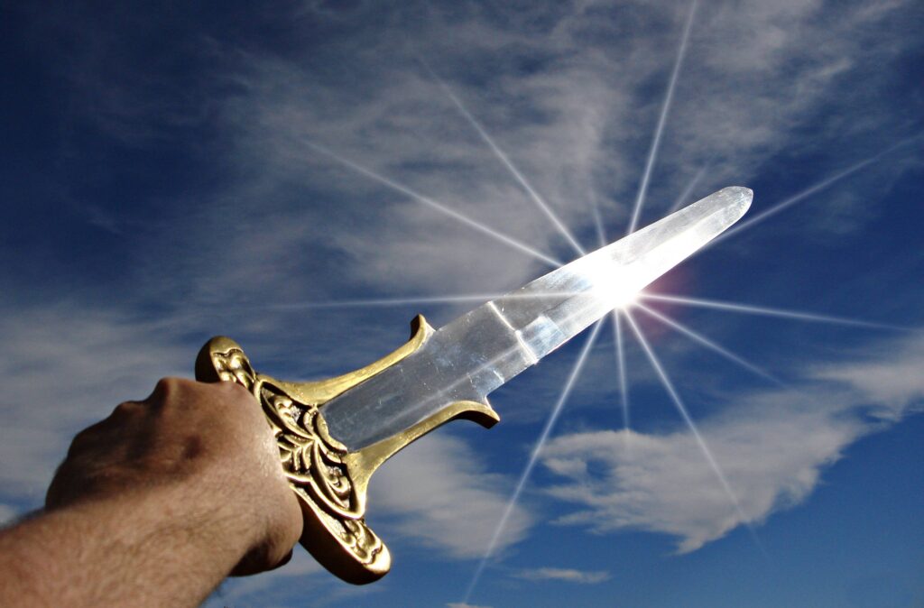 יד מחזיקה חרב ברקע שמים ונצנוץ של השמש
